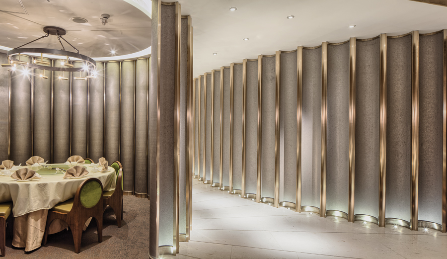 Curved brass modules frame a VIP dining area to the side of the main entrance