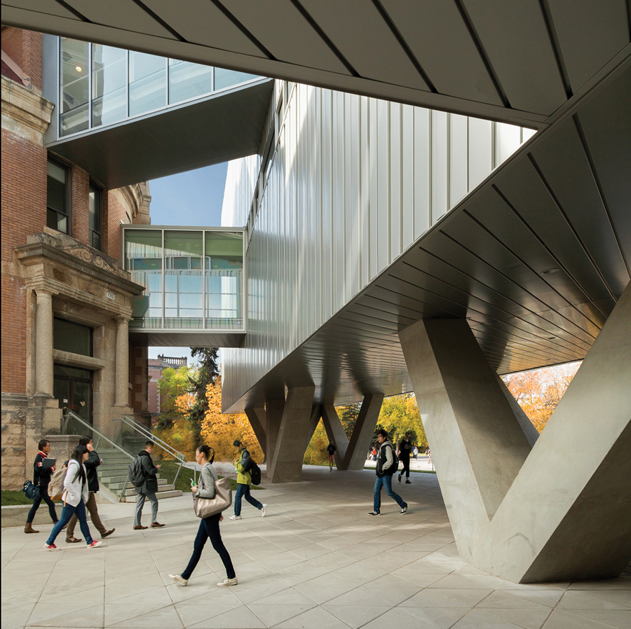 The entry is tucked beneath a massive overhang supported on sculpted columns.