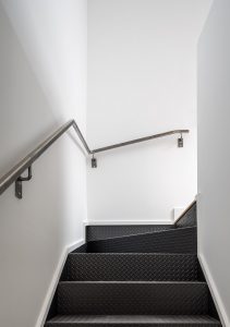Checker-patterned steel stairs are used throughout, making use of economical industrially produced materials.