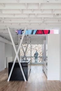 In the upper unit, X-shaped columns to either side of the kitchen island maximize structural efficiency while adding minimalist flair.